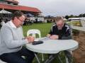 Terry Brinkworth and Greg Fahey, from Newcastle, study the form guide after being among the first to arrive at the Murrumbidgee Turf Club for Friday's Wagga Gold Cup. Picture by Tom Dennis 